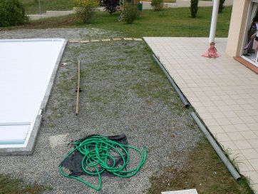 Der Boden wird beim Einbau des Pools mit verstreutem Kies bestreut.